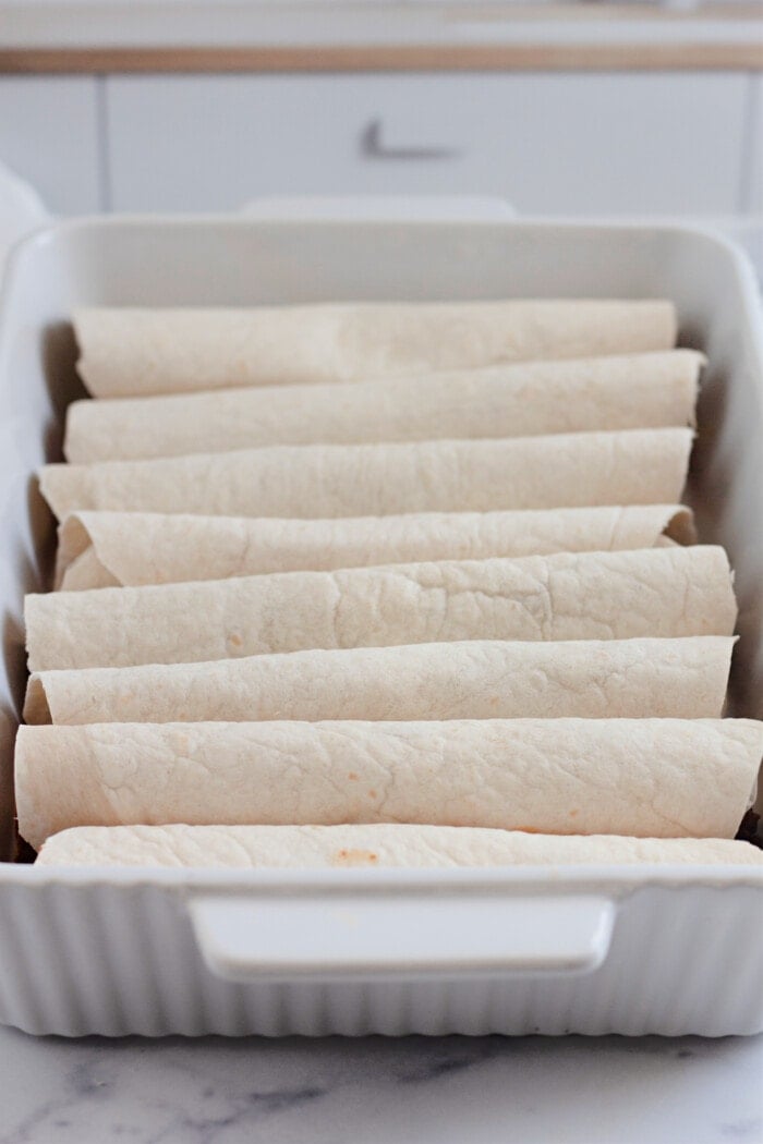 Filled and rolled tortillas in a baking dish