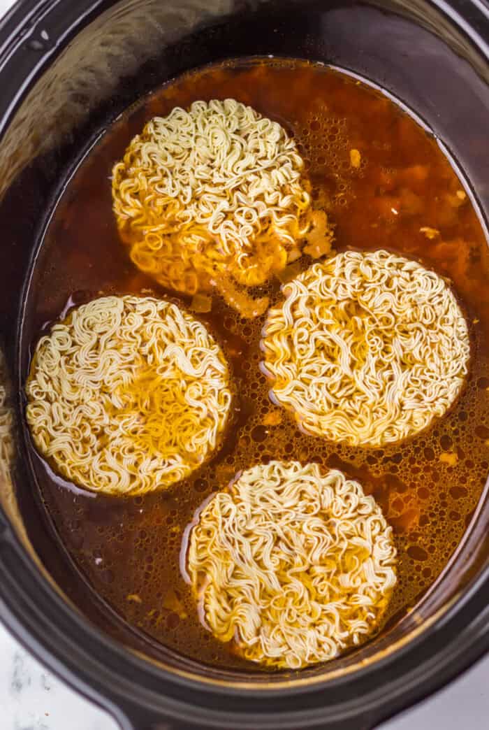 Ramen added to a slow cooker with birria meat