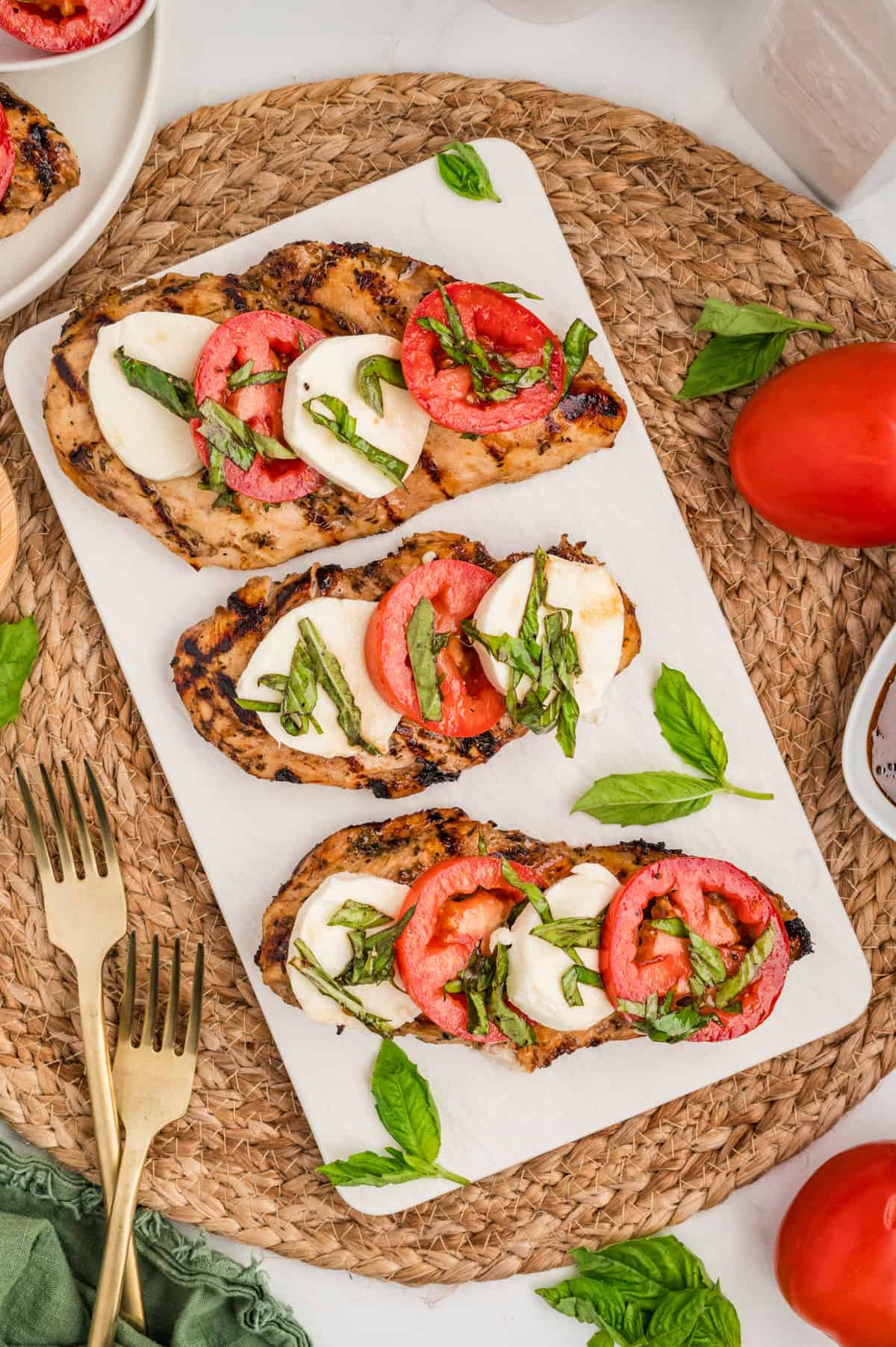 Overhead view of three pieces of chicken caprese on a platter