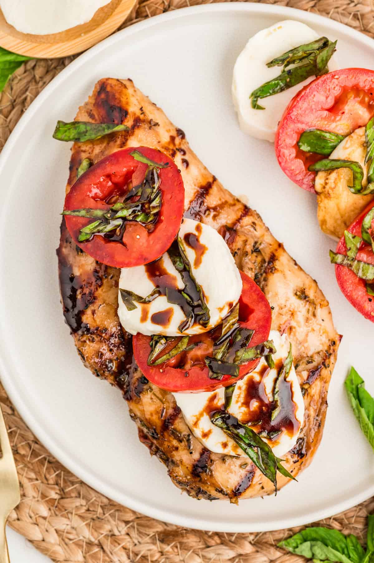Overhead view of chicken caprese on a white plate