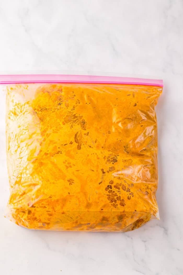 Chicken thighs marinating in a ziploc bag