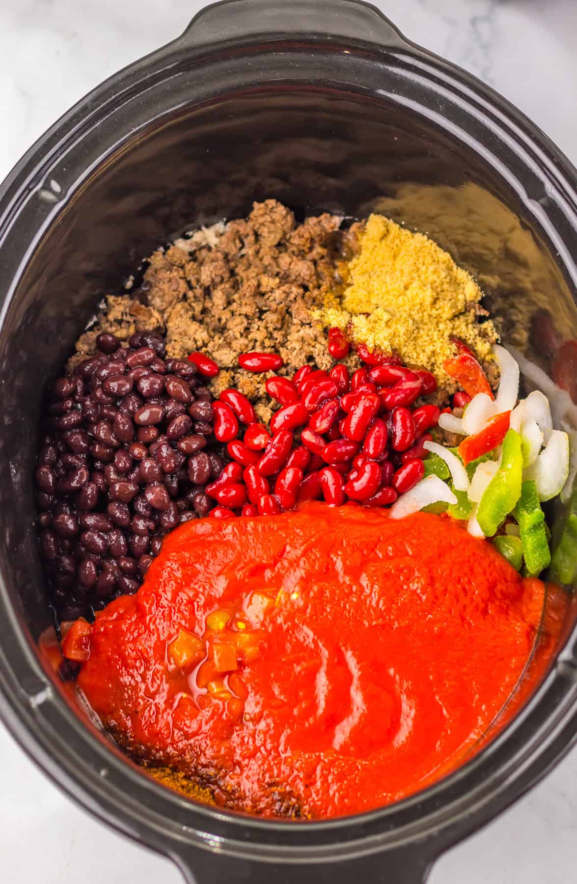 ground beef, beans, vegetables and seasonings in slow cooker