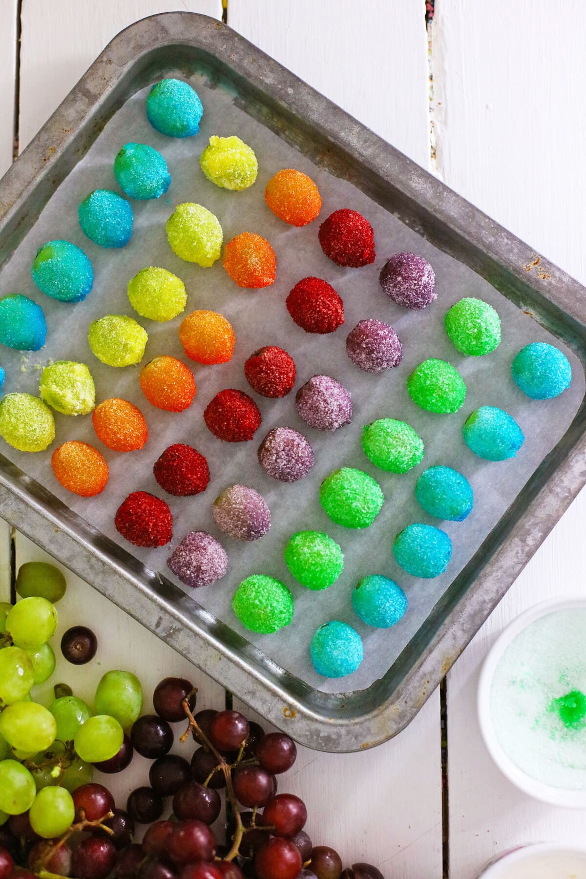 Candy Grapes are frozen grapes dipped and coated in a thin layer of vibrant and flavored Jello mix. Frozen Jello Grapes on a Tray