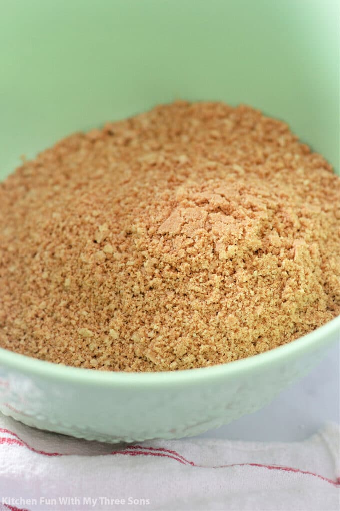 crushed cookies in a mint green mixing bowl.