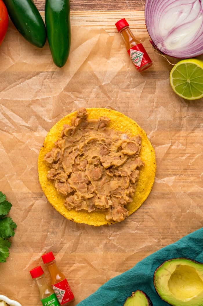 Refried beans spread on a tostada shell